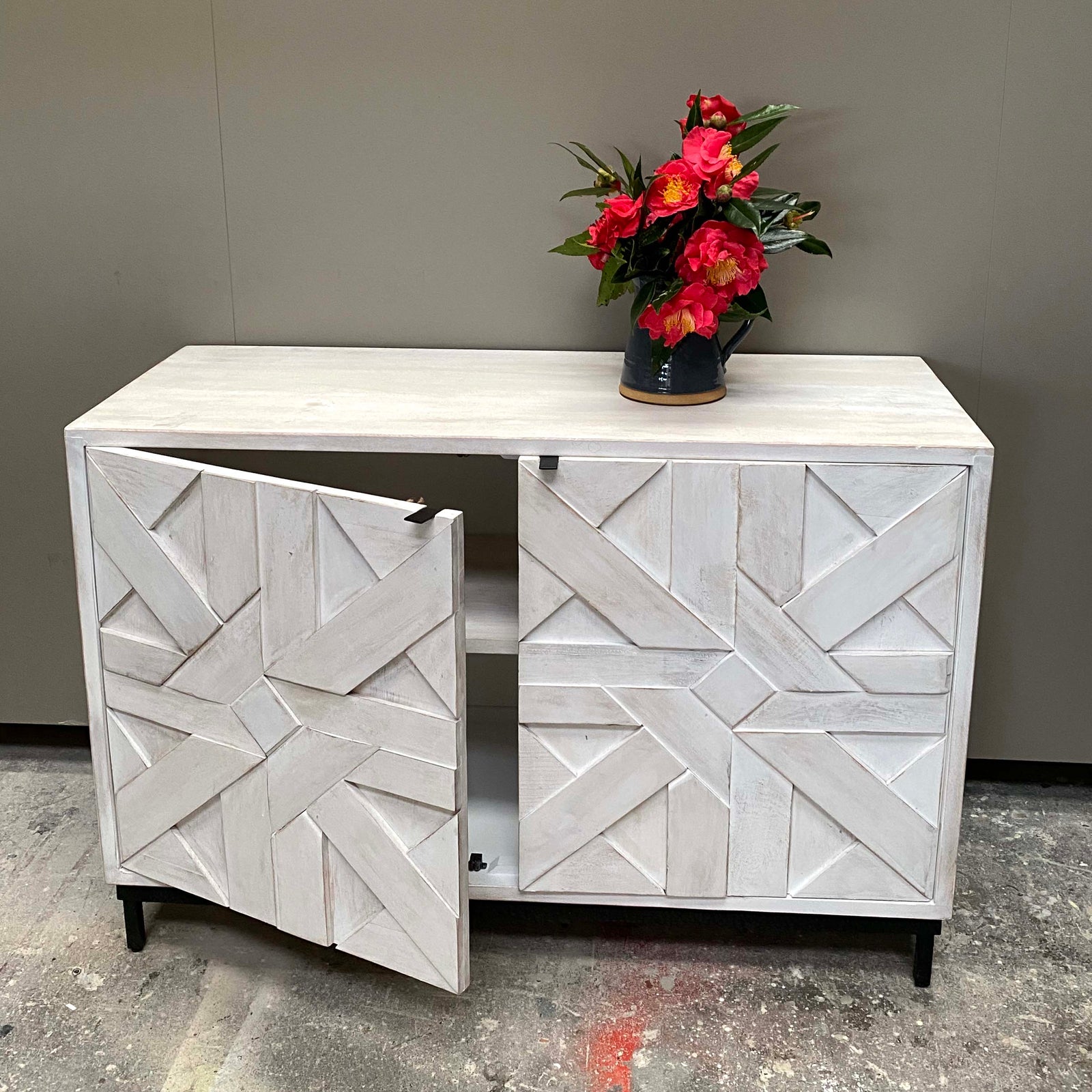 White cabinet with geometric design on doors.