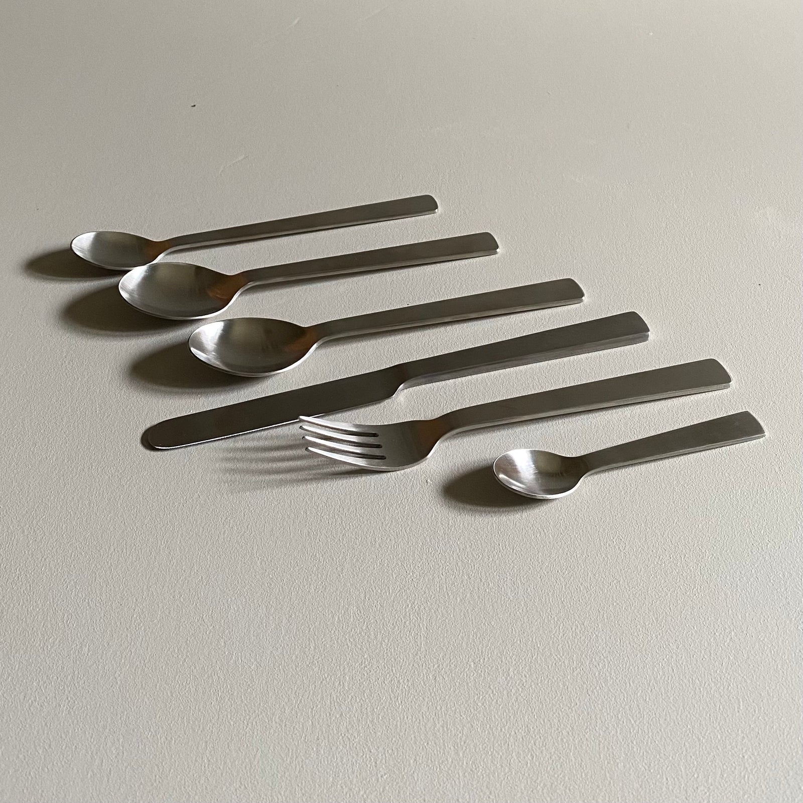 Stainless steel cutlery set on a marble surface